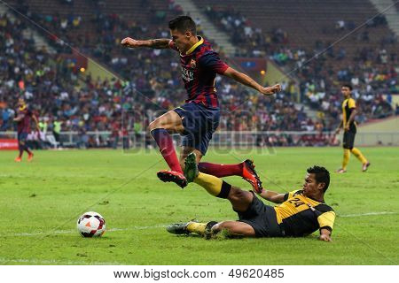 KUALA LUMPUR - AUGUST 10: FC Barcelona's Cristian Tello (maroon/blue) dribbles the ball in a match vs Malaysia at the Shah Alam Stadium on Aug 10, 2013 in Kuala Lumpur, Malaysia. Barcelona wins 3-1.