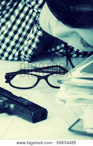 Female kild her self while filling out tax forms while sitting at her desk.