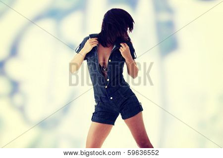 Sexy, beautiful, young woman dancing (hair flying) in jeans siut
