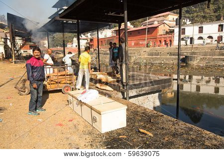 KATHMANDU, NEPAL - DEC 3, 2013: Unidentified local people during the cremation ceremony along the holy Bagmati River in Bhasmeshvar Ghat at Pashupatinath temple in Kathmandu.