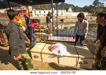 KATHMANDU, NEPAL - DEC 3, 2013: Unidentified local people during the cremation ceremony along the holy Bagmati River in Bhasmeshvar Ghat at Pashupatinath temple in Kathmandu.