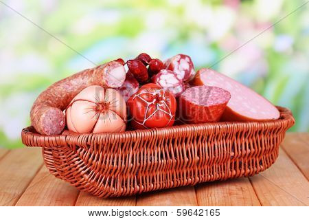 Different sausages on wooden table on natural background