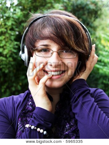 Usmívající se dívka poslouchá hudbu