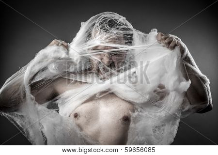 Danger. man tangled in huge white spider web