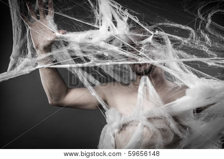 Connection.man tangled in huge white spider web