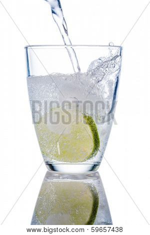 a glass of fresh drinking water and a lime. mineral water as a thirst quencher.