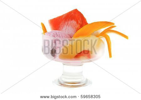 small transparent glass cup with ice cream and tropical fruits isolated on white background