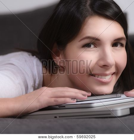 Smiling Young Woman Resting Her Chin On A Tablet