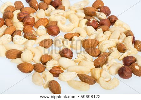 mixed nuts - hazelnuts walnuts cashews pine nuts isolated on white background