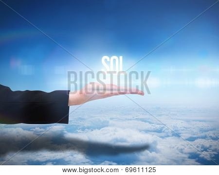 Businesswomans hand presenting the word sql against blue sky over clouds at high altitude