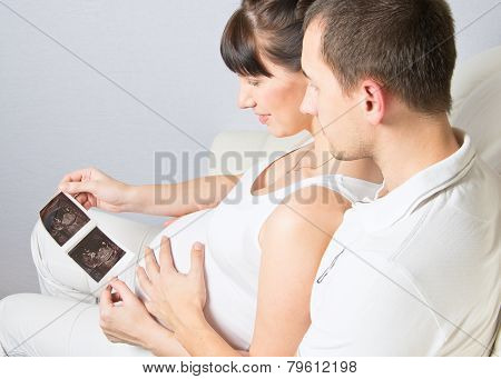 Young Couple Looking At Their Baby Ultrasound Picture