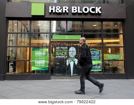 NEW YORK CITY - MONDAY, DEC. 29, 2014: Pedestrians walk past an office of H&R Block. H&R Block is a tax preparation company in the United States