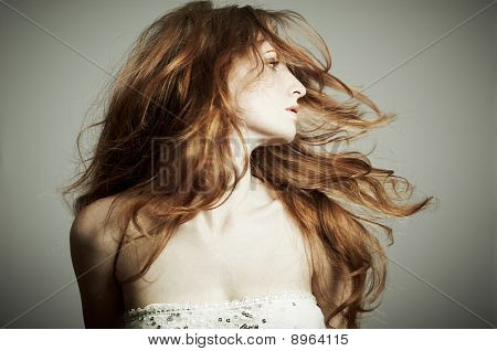 Retrato de la mujer hermosa con el pelo rizado rojo