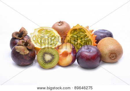 Various fruits: kiwano, mangosteen, plums and kiwi on white background