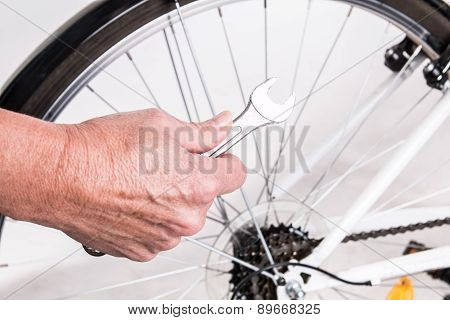 Woman Hand Repair Bicycle Whee With Screw Key