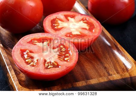 Cool Fresh Tomatoes, Whole And Half On Wooden Tray And Wooden Background