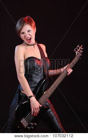 Sexy girl in leather clothes with bass guitar