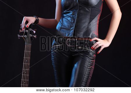 Sexy girl in leather clothes with bass guitar