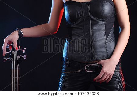 Sexy girl in leather clothes with bass guitar