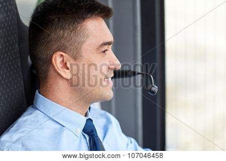 transport, tourism, road trip and people concept - happy bus driver face with microphone