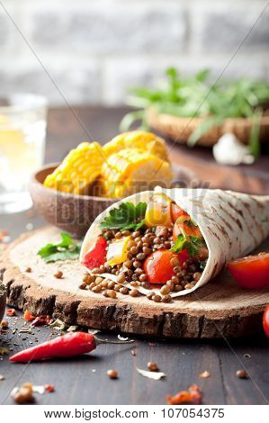 Vegan tortilla wrap, roll with grilled vegetabes, lentil, corn cob.