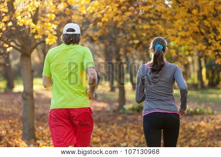 Young couple running in autumn season. Concept of fitness exercise and bidy training