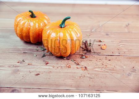 Pumpkin ornaments on desk with pot pourri