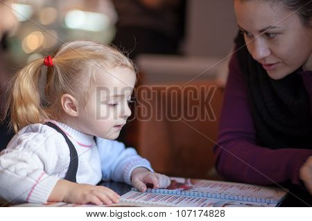 Little Girl Choosing Foood From Menu