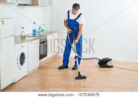 Worker Cleaning Floor With Vacuum Cleaner
