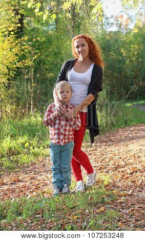 Young Mother And Her Little Son In Autumn Park At Sunny Day