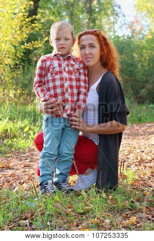 Young Mother And Handsome Little Son In Autumn Park At Sunny Day