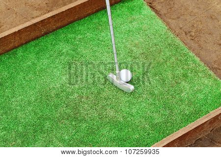 Artificial Lawn, Putter And Golf Ball On Wooden Stand For Training