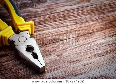 multitool pliers on wooden background