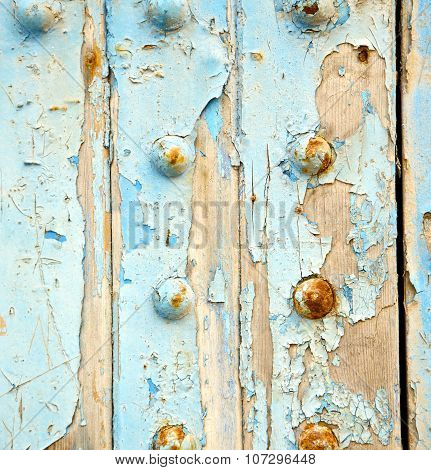 Dirty Stripped Paint In The Blue Wood Door And Rusty Nail