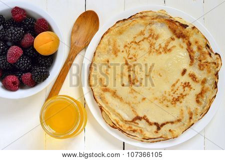 ?repes fresh berries and honey on wooden background