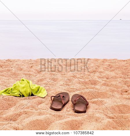 And Slippers And A Towel Left On The Sand On The Beach