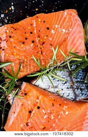 Portions Of Fresh Raw Salmon Fillets With Aromatic Herbs And Olive Oil