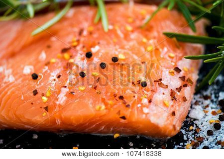 Portions Of Fresh Raw Salmon Fillets With Aromatic Herbs And Olive Oil