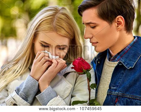 Upset girl  with cold rhinitis on autumn outdoor. Fall flu season. Man looks with compassion on suffering of loved one.