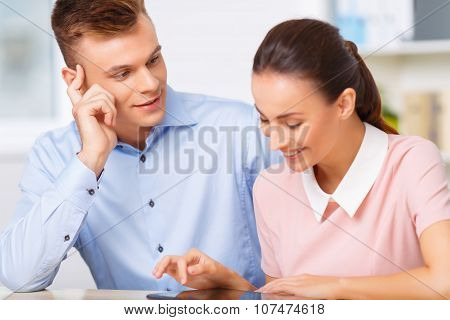 Young manager watches his sweetheart at work.