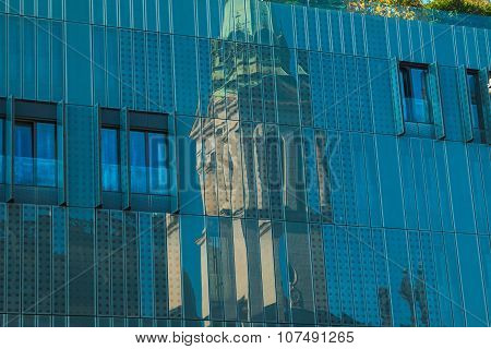 Reflection of orthodox church in facade of modern business building on Preradovic square (Flower squ