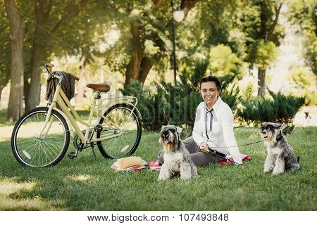 Young Woman With Dogs And Bicycle Having Picnic In The Park