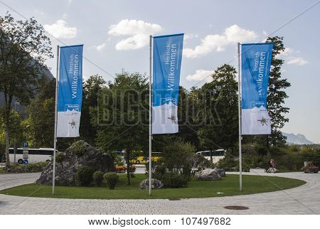 KOENIGSSEE, GERMANY - AUGUST 13, 2015: Flags at the entrance to the Koenigssee are waving in the wind and are showing an advertisment of the Berchtesgadener Land region