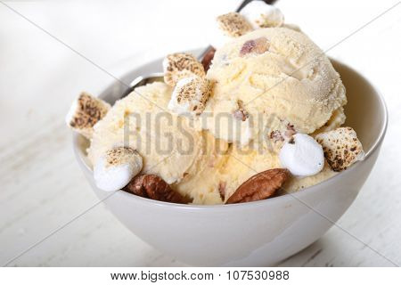 Bowl of delicious butter pecan ice cream with toasted pecans and marshmallows