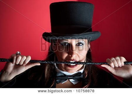 Kobieta w Top Hat gryzienie bicz