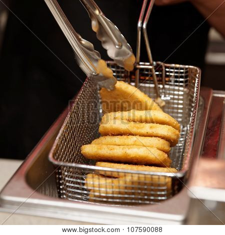Chef is cooking nuggets in a deep fryer