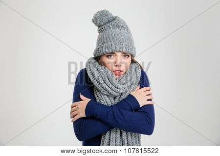 Portrait of a freezing woman in winter cloth standing isolated on a white background