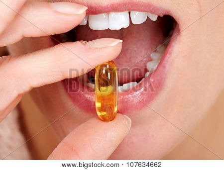 Woman mouth eating pills. Health care concept.