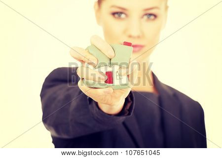 Aggresive businesswoman crushing small house.