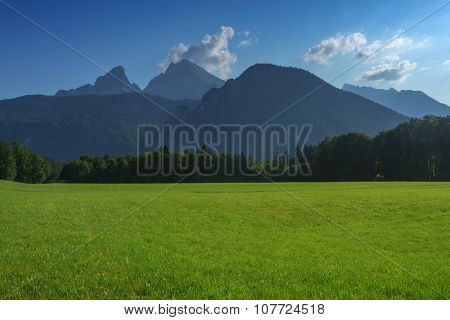 Beautiful view from green meadow on high mountains. Alps, Europe.